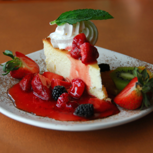 slice of vegan and gluten free cheesecake topped with berries